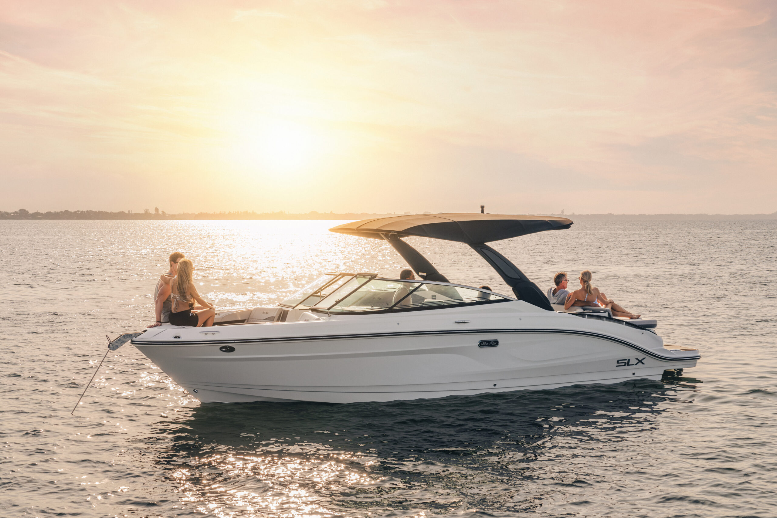 Friends aboard an SLX 280 at sunset